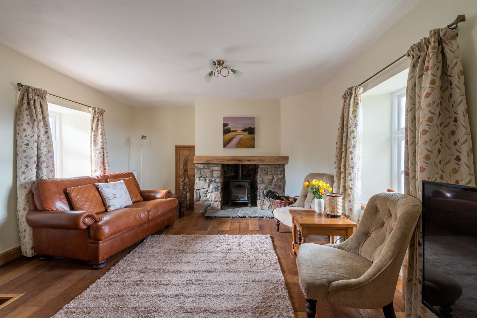 Lounge with stone fireplace and wood-burning stove