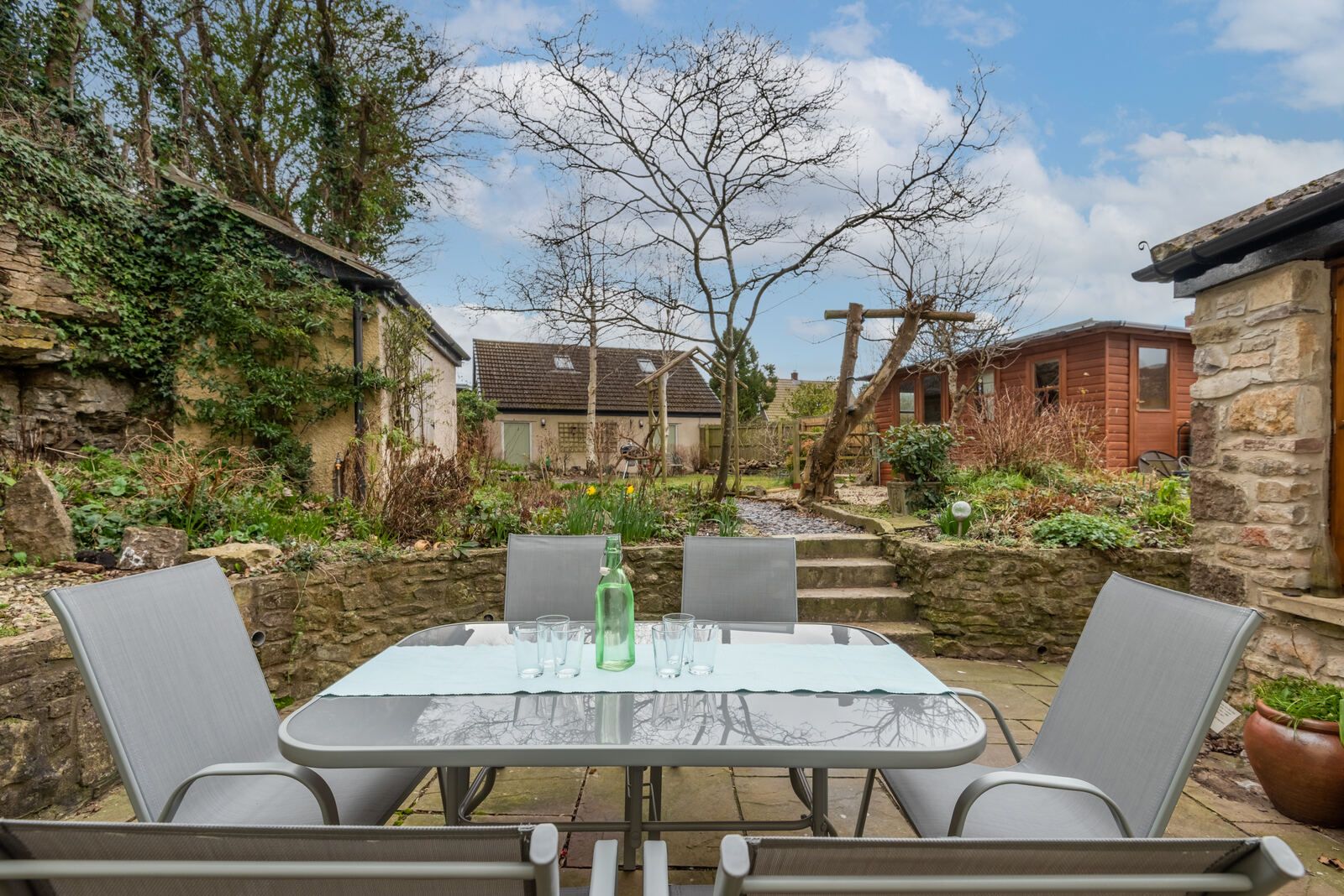 Patio table and chairs below the garden